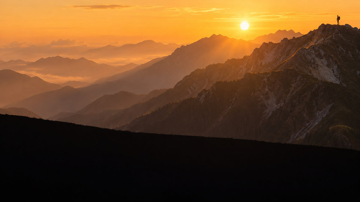 Outdoor Hikers hero, Japanese alpine ridgeline at golden hour with a distant hiker in silhouette